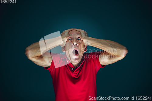 Image of Close up portrait of crazy scared and shocked man isolated on dark background