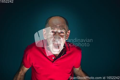 Image of Close up portrait of crazy scared and shocked man isolated on dark background