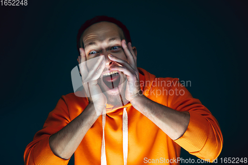 Image of Close up portrait of crazy scared and shocked man isolated on dark background