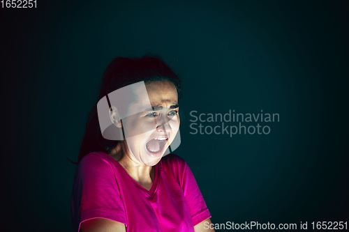 Image of Close up portrait of young crazy scared and shocked woman isolated on dark background