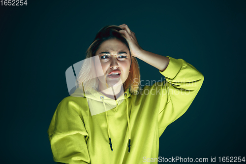 Image of Close up portrait of young crazy scared and shocked woman isolated on dark background