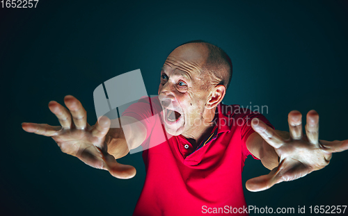 Image of Close up portrait of crazy scared and shocked man isolated on dark background