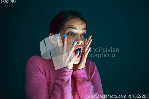 Image of Close up portrait of young crazy scared and shocked woman isolated on dark background