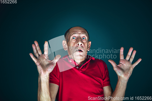 Image of Close up portrait of crazy scared and shocked man isolated on dark background