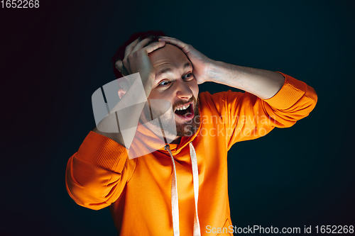 Image of Close up portrait of crazy scared and shocked man isolated on dark background