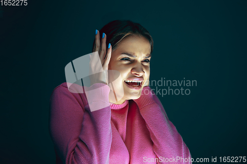 Image of Close up portrait of young crazy scared and shocked woman isolated on dark background