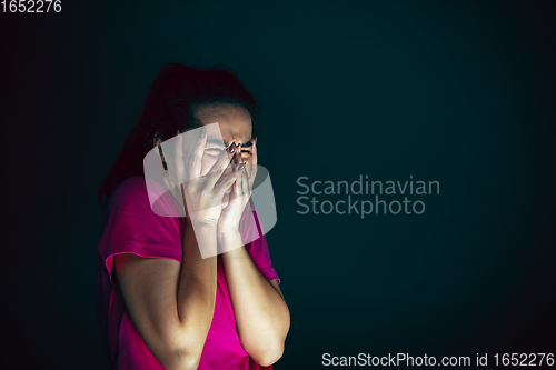 Image of Close up portrait of young crazy scared and shocked woman isolated on dark background