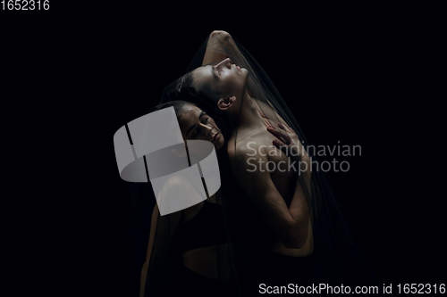 Image of Graceful classic ballet dancers isolated on black studio background. The grace, artist, movement, action and motion concept.