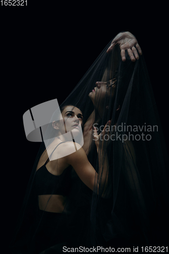 Image of Graceful classic ballet dancers isolated on black studio background. The grace, artist, movement, action and motion concept.