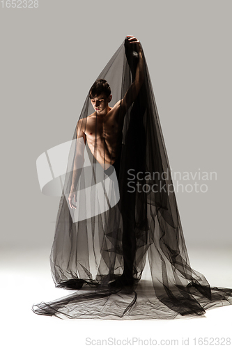 Image of Graceful classic ballet dancer in black cloth isolated on white studio background. The grace, artist, movement, action and motion concept.