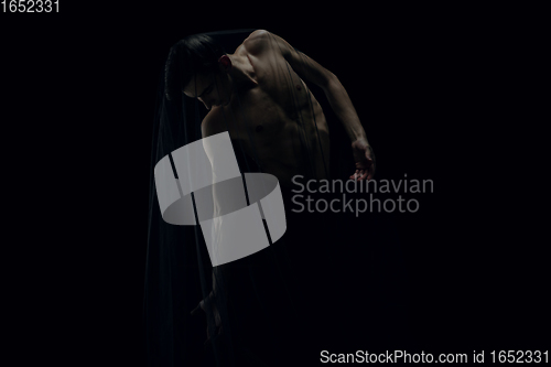 Image of Graceful classic ballet dancer dancing isolated on dark studio background. The grace, artist, movement, action and motion concept.