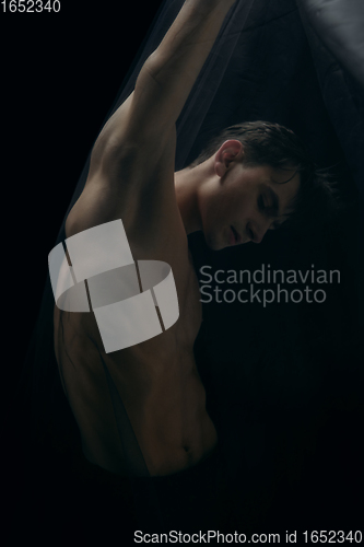 Image of Graceful classic ballet dancer dancing isolated on dark studio background. The grace, artist, movement, action and motion concept.