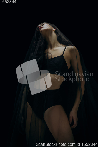 Image of Graceful classic female ballet dancer isolated on black studio background. The grace, artist, movement, action and motion concept.