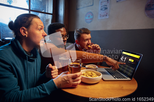 Image of Excited fans with mobile app for betting and score on their devices. Gambling, emotions