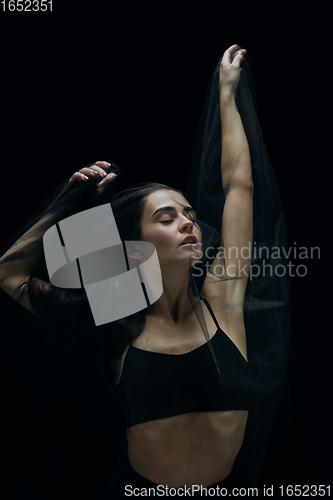 Image of Graceful classic female ballet dancer isolated on black studio background. The grace, artist, movement, action and motion concept.