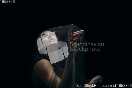 Image of Graceful classic female ballet dancer isolated on black studio background. The grace, artist, movement, action and motion concept.