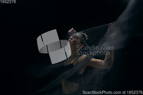 Image of Graceful classic female ballet dancer isolated on black studio background. The grace, artist, movement, action and motion concept.