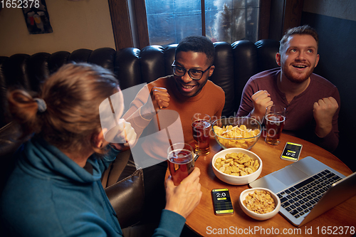 Image of Excited fans with mobile app for betting and score on their devices. Gambling, emotions