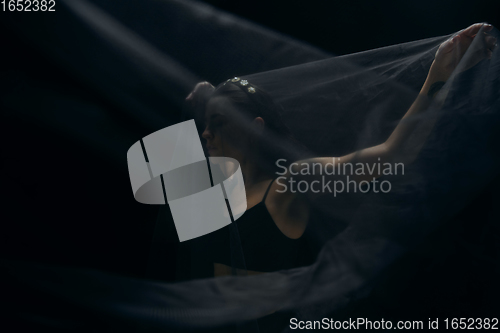Image of Graceful classic female ballet dancer isolated on black studio background. The grace, artist, movement, action and motion concept.