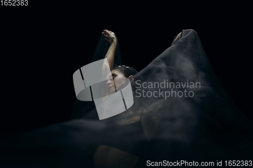 Image of Graceful classic female ballet dancer isolated on black studio background. The grace, artist, movement, action and motion concept.