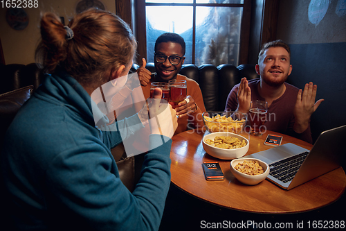 Image of Excited fans with mobile app for betting and score on their devices. Gambling, emotions