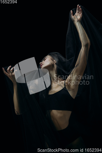 Image of Graceful classic female ballet dancer isolated on black studio background. The grace, artist, movement, action and motion concept.