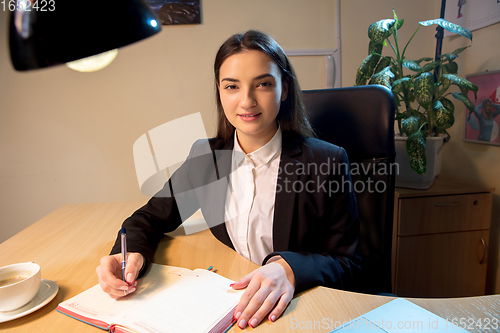 Image of Young woman talking, working during videoconference with colleagues at home