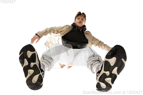 Image of Young stylish man in modern street style outfit isolated on white background, shot from the bottom