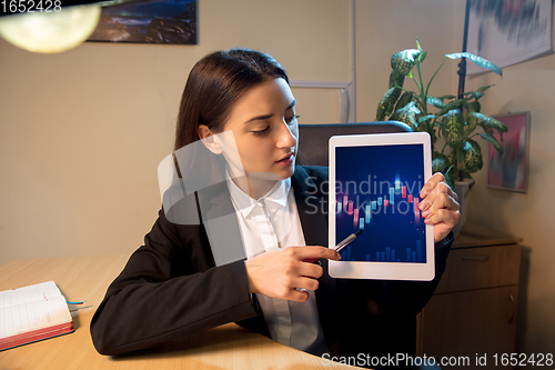 Image of Young woman talking, working during videoconference with colleagues at home
