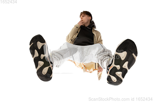 Image of Young stylish man in modern street style outfit isolated on white background, shot from the bottom