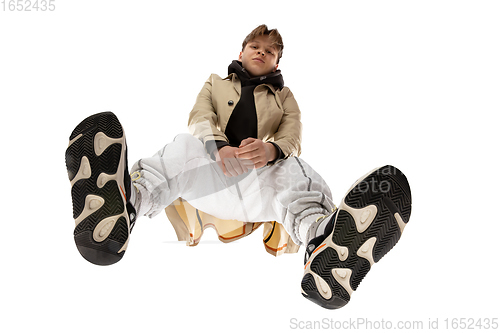 Image of Young stylish man in modern street style outfit isolated on white background, shot from the bottom