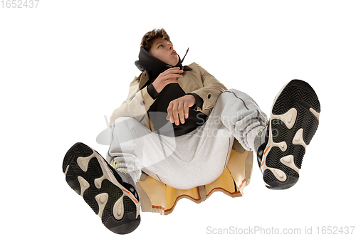 Image of Young stylish man in modern street style outfit isolated on white background, shot from the bottom