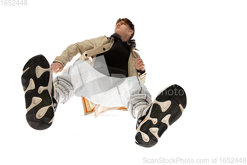 Image of Young stylish man in modern street style outfit isolated on white background, shot from the bottom