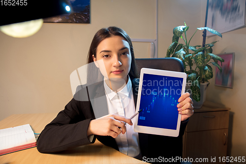 Image of Young woman talking, working during videoconference with colleagues at home