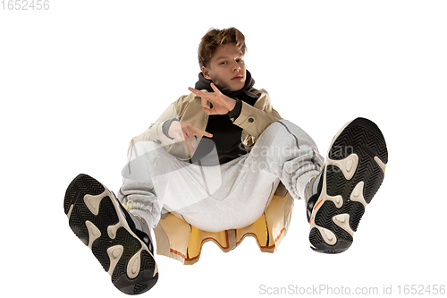 Image of Young stylish man in modern street style outfit isolated on white background, shot from the bottom