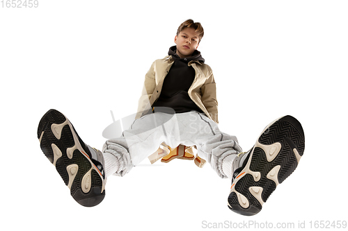 Image of Young stylish man in modern street style outfit isolated on white background, shot from the bottom
