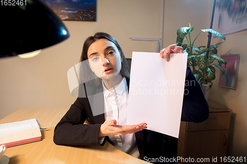 Image of Young woman talking, working during videoconference with colleagues at home