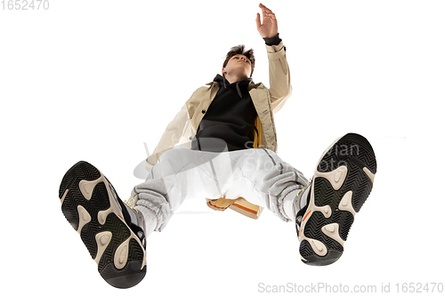 Image of Young stylish man in modern street style outfit isolated on white background, shot from the bottom