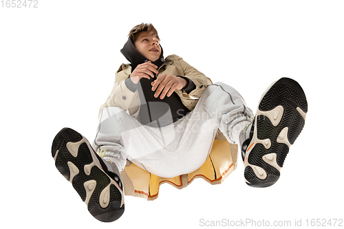 Image of Young stylish man in modern street style outfit isolated on white background, shot from the bottom