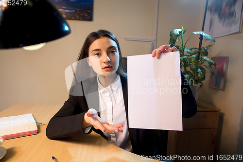 Image of Young woman talking, working during videoconference with colleagues at home