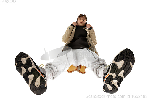 Image of Young stylish man in modern street style outfit isolated on white background, shot from the bottom