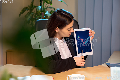 Image of Young woman talking, working during videoconference with colleagues at home