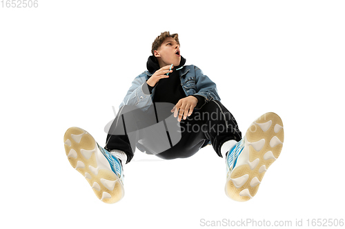 Image of Young stylish man in modern street style outfit isolated on white background, shot from the bottom