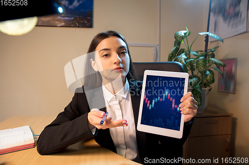 Image of Young woman talking, working during videoconference with colleagues at home