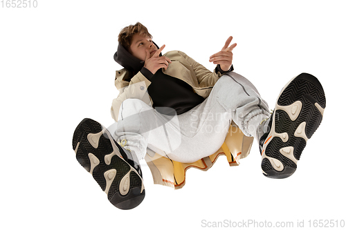 Image of Young stylish man in modern street style outfit isolated on white background, shot from the bottom