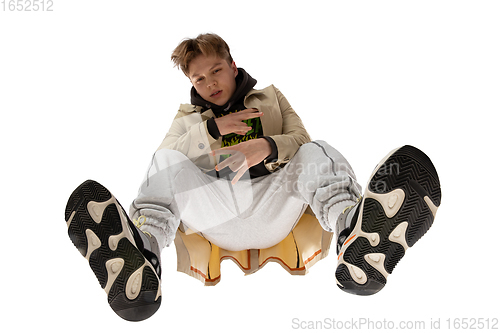 Image of Young stylish man in modern street style outfit isolated on white background, shot from the bottom