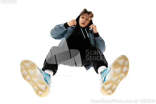 Image of Young stylish man in modern street style outfit isolated on white background, shot from the bottom