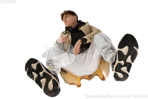 Image of Young stylish man in modern street style outfit isolated on white background, shot from the bottom