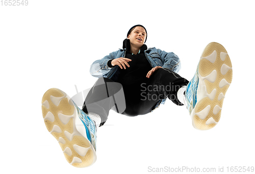 Image of Young stylish man in modern street style outfit isolated on white background, shot from the bottom