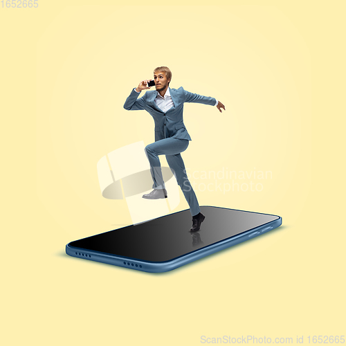 Image of Office worker, businessman running on the surface of smartphone\'s screen isolated on background